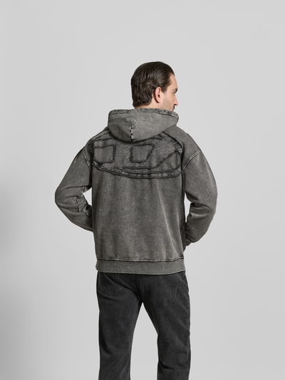 Männermodel trägt Relaxed Fit Hoodie in Denim-Optik von Diesel, Reine Baumwolle, Logo-Stitching, graue Töne, Rückenlänge 69 cm, Ganzkörperansicht Rückansicht.