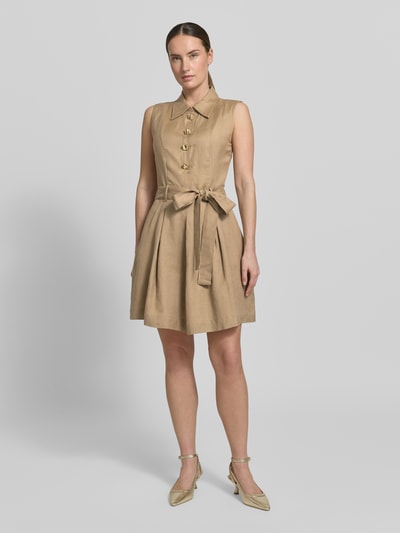 Kobiece modelka nosi tailliertes Freizeitkleid aus Leinen-Viskose-Mix Modell 'KALEISI' von HUGO, efekt: jednolity kolor, taliowany krój, długość midi, wysokie zapięcie, aplikacja: ozdobne guziki, szlufki na pasek, wiązany pasek, zapięcie: ukryty zamek błyskawiczny, szerokie ramiączka, wpuszczane kieszenie, wykończenie materiału: cieniowana przędza, mieszanka lnu i wiskozy, całkowity widok od przodu.