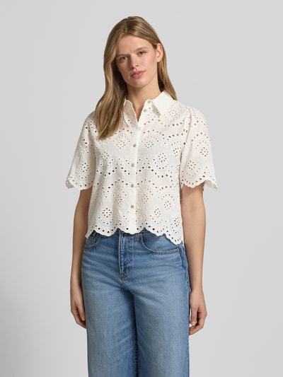Frauenmodel trägt Loose Fit Bluse mit Lochstickerei Modell 'VALAIS' von Only, weiße Baumwolle, Hemdkragen, einreihige Knopfleiste, unifarben, florale Muster, lange Ärmel mit Manschetten, Ganzkörperansicht von vorne.