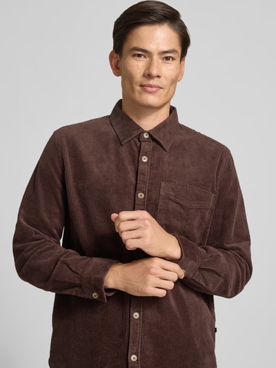 Männermodel trägt Comfort Fit Hemdjacke aus Baumwoll-Mix von s.Oliver RED LABEL, braun, feine Cordstruktur, Nahaufnahme Oberkörper.