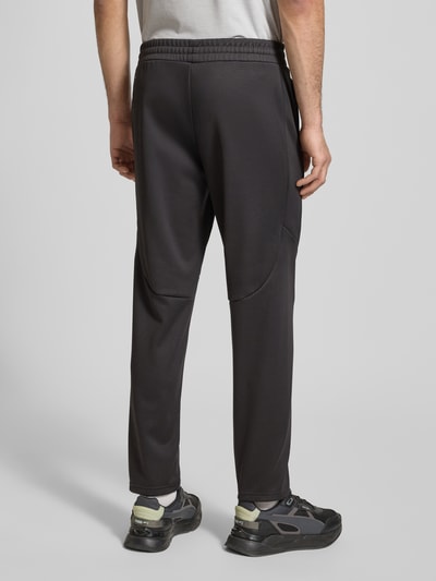 Männermodel trägt Sweatpants mit elastischem Bund von PUMA PERFORMANCE, lockerer Schnitt, Label-Print, Rückansicht Ganzkörperansicht.