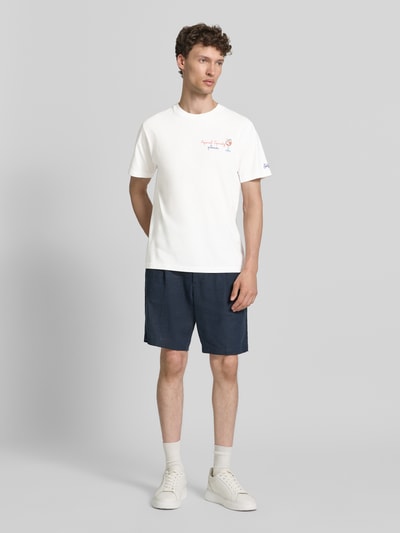 Męski model nosi t-shirt z haftami model 'PORTOFINO' od MC2 Saint Barth, bawełna, krój regular fit, okrągły dekolt, długość tyłu w rozmiarze M 68 cm, kolor biały, gładka tekstura, widok całej sylwetki z przodu.