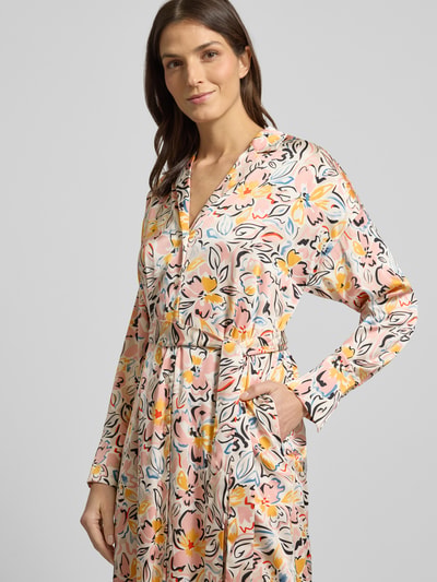 Frauenmodel trägt Midikleid mit Allover-Muster von Christian Berg Woman Selection, Material-Mix mit Stretch-Anteil, taillierter Schnitt, V-Ausschnitt, Taillengürtel, Reverskragen, Mehrfarbig mit floralen und grafischen Formen, glatte Textur, Nahaufnahme Oberkörper.