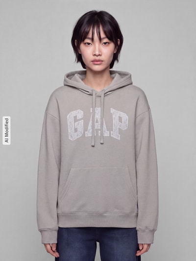 Kobieta modelka nosi szarą bluzę Regular Fit Sweatshirt aus Baumwoll-Mix model 'HERITAGE PO' od GAP, gładka tekstura, damska bluza GAP, Ganzkörperansicht von vorne, KI-modifiziertes Bild.