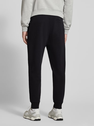 Männermodel trägt schwarze Regular Fit Sweathose aus Baumwoll-Mix Modell 'C-Locsin 01' von BOSS, Herren Sweathose, Ganzkörperansicht Rückansicht.