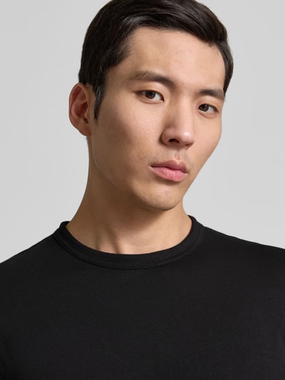 Männermodel trägt Regular Fit Langarmshirt aus reiner Baumwolle von Tom Tailor in Schwarz, Rundhalsausschnitt, unifarben, Nahaufnahme Oberkörper.