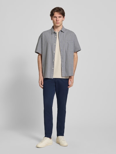 Männermodel trägt Slim Fit HOSE in Knöchellänge Modell 'Marco' von Jack & Jones aus Baumwoll-Mix in Dunkelblau, Eingriffstaschen, Ganzkörperansicht von vorne.
