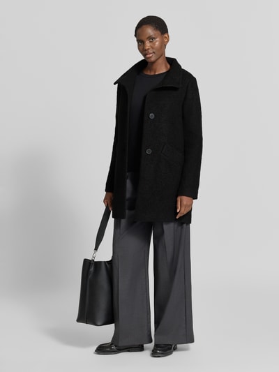 Frauenmodel trägt schwarze Regular Fit Jacke aus Woll-Mix von FUCHS SCHMITT mit Stehkragen, Eingrifftaschen, Knopfleiste, Ganzkörperansicht von vorne.