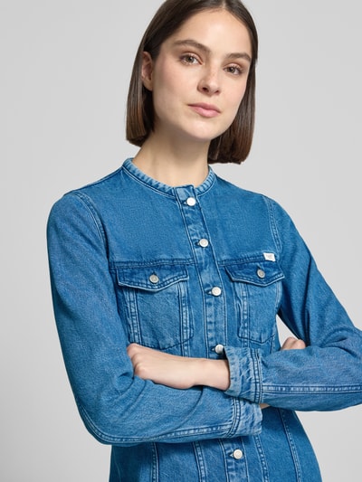 Vrouwenmodel draagt dames denimjurk van puur katoen, getailleerd model, borstzakken, model 'PAOLA ALTO' van Mustang, nahaufnahme bovenlichaam.