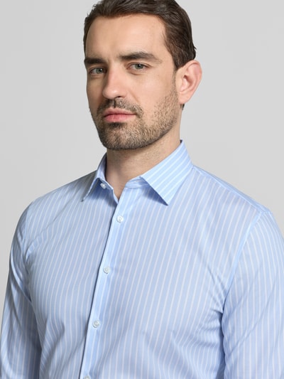 Männermodel trägt Super Slim Fit Business-Hemd mit Kentkragen von OLYMP No. Six, hellblau mit weißen Streifen, Nahaufnahme Oberkörper