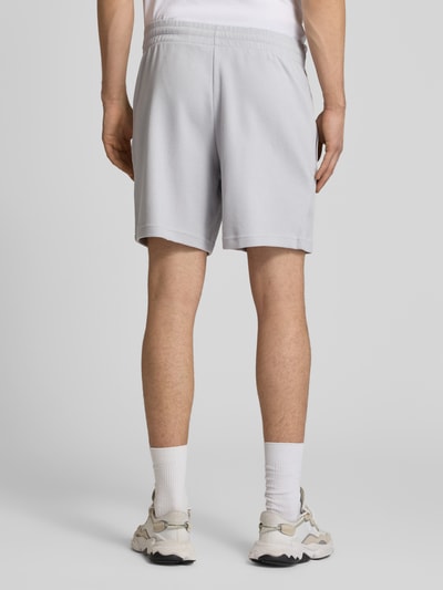 Männermodel trägt Regular Fit Sweatshorts mit Baumwoll-Anteil von adidas Originals, Optik: Unifarben, Waffelstruktur, Ganzkörperansicht Rückansicht.