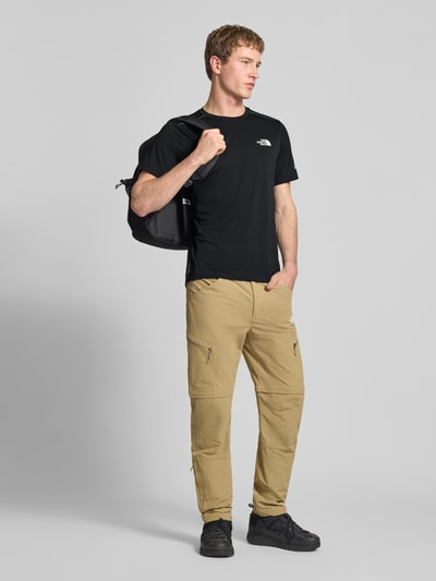 Mannenmodel draagt T-Shirt met Logo en Rundhalsausschnitt van The North Face, regular fit, zwarte kleur, voorkant volledige lichaamsaanzicht.