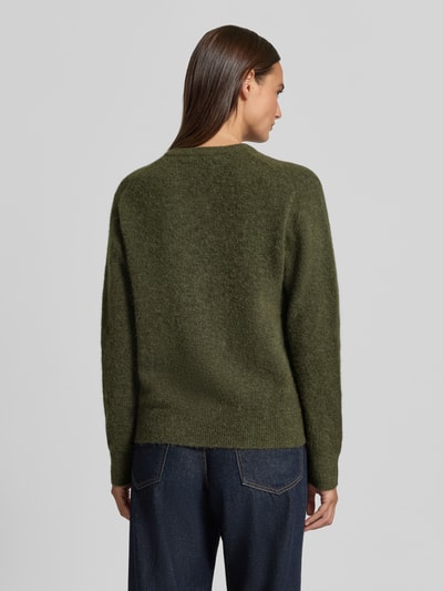 Frauenmodel trägt Regular Fit Cardigan aus Woll-Alpaka-Mix Modell 'NOR' von Samsøe Samsøe in Dunkelgrün, Strick-Optik, Ganzkörperansicht Rückansicht. Rückenlänge bei Größe S: 59 cm, Ärmellänge 62 cm, elastisch, langärmelig, Rundhalsausschnitt, durchgehende Knopfleiste.
