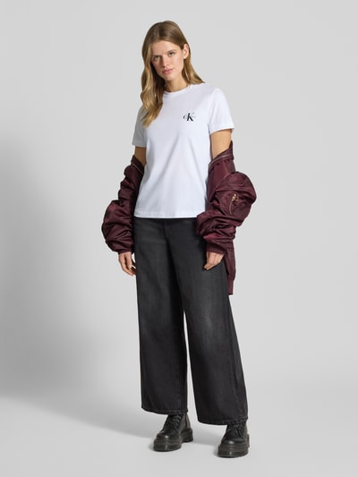 Modelka nosi T-Shirt Set mit Logo und Rundhalsausschnitt von Calvin Klein Jeans z czystej bawełny, krój regular fit, biała koszulka, przód, ujęcie całej sylwetki