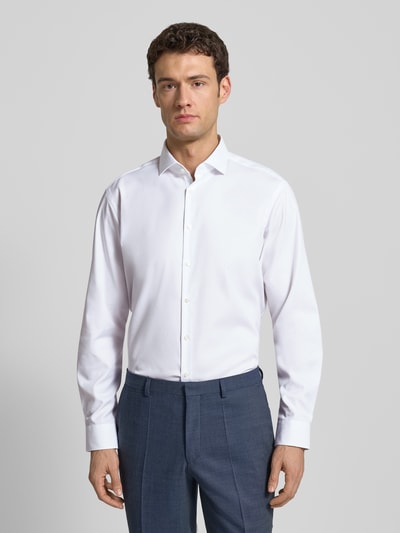 Männermodel trägt Modern Fit Business-Hemd mit Haifischkragen von Jake*s, Reine Baumwolle, weiß, Knopfleiste, Ganzkörperansicht von vorne. Rückenlänge 80 cm, Schulterbreite 45 cm, Ärmellänge 65 cm bei Größe 41/42.