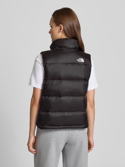 Frauenmodel trägt Steppweste mit Label-Stitching Modell 'HYDRENALITE DOWN A-LINE' von The North Face in Schwarz, glatte Textur, Ganzkörperansicht Rückansicht. Regular Fit, Stehkragen, Reißverschluss und Reißverschlusstaschen, Rückenlänge 55 cm, Schulterbreite 37 cm, Brustweite 53 cm.