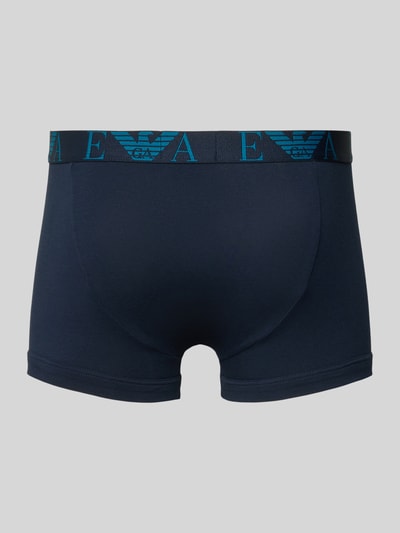 Männermodel trägt Trunks im 3er-Pack mit elastischem Logo-Bund von Emporio Armani aus Baumwoll-Mix mit Stretch-Anteil, Ganzkörperansicht Rückansicht.
