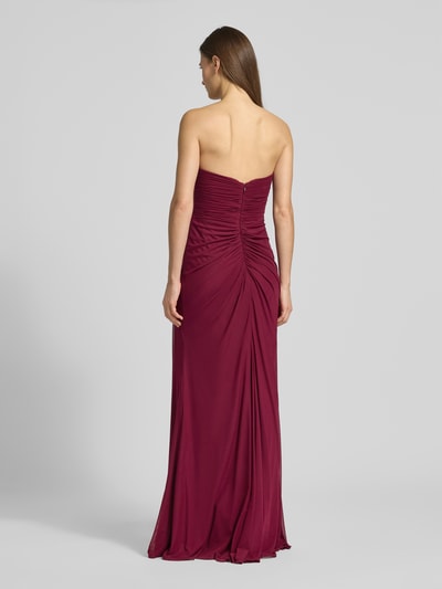 Frauenmodel trägt Regular Fit Abendkleid mit Gehschlitz von Mascara, Mesh, Raffung, schulterfrei, Nahtreißverschluss, Rückenansicht Ganzkörperansicht.