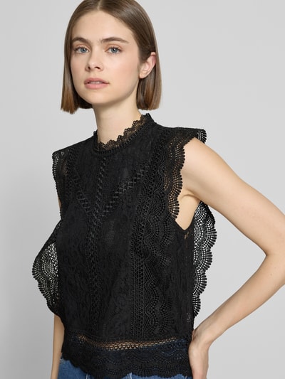 Frauenmodel trägt Slim Fit Blusentop mit Baumwoll-Viskose-Lyocell-Anteil Modell 'KARO' von Only, Schwarz, abstraktes Muster, Spitze, Nahaufnahme Oberkörper.