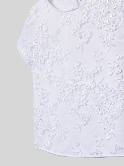 Mädchen trägt Maxikleid mit Rundhalsausschnitt von DANAMADE, taillierter Schnitt, Schleifen-Detail, weiße Spitze, Nahaufnahme Oberkörper.