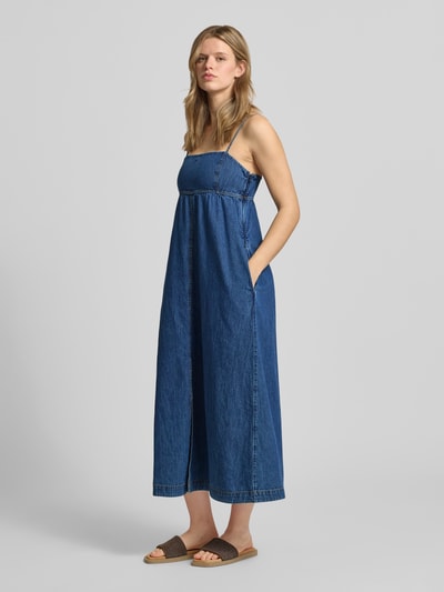 Frauenmodel trägt Maxi Freizeitkleid aus reiner Baumwolle von Tommy Jeans in Denim-Optik mit Karree-Ausschnitt, Ganzkörperansicht von vorne.