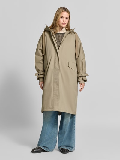 Vrouwenmodel draagt lange jas Relaxed Fit Mantel aus Baumwoll-Mix Model 'Livia' van g-lab in beige katoenmix met capuchon, elastische mouwboord, ruglengte 109 cm, schouderbreedte 53 cm, borstwijdte 72 cm, mouwlengte 55 cm, geheel vooraanzicht.