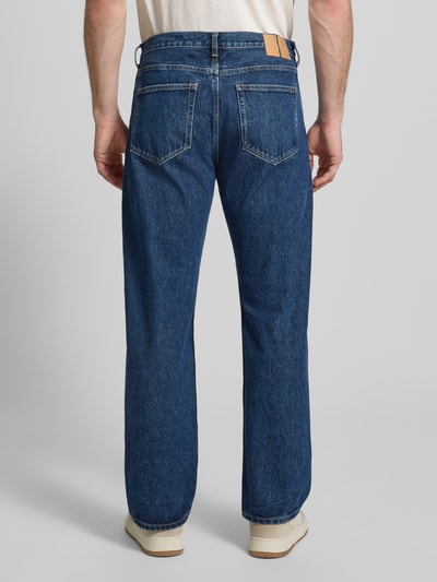 Männermodel trägt Jeans im Used-Look Modell 'Type 2' von Wood Wood in Blau, Relaxed Fit, reine Baumwolle, Ganzkörperansicht Rückansicht.