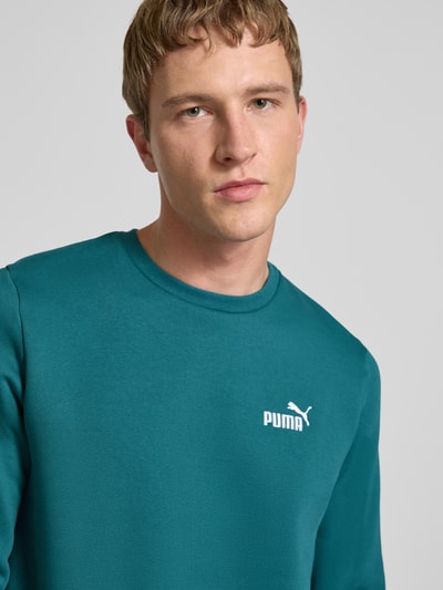 Männermodel trägt Regular Fit Sweatshirt mit Logo-Stitching von PUMA PERFORMANCE, mieszanka bawełny, okrągły dekolt, wyhaftowane logo, Nahaufnahme Oberkörper.