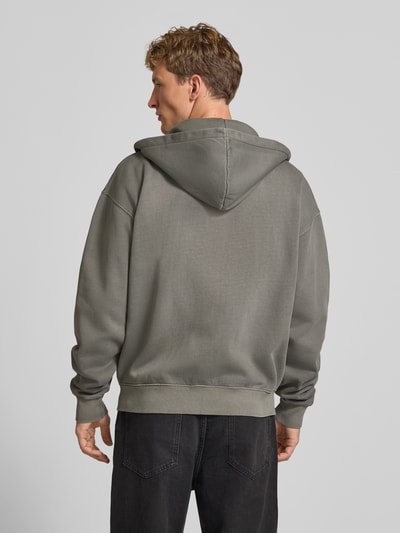 Männermodel trägt Regular Fit Sweatjacke aus Baumwoll-Mix von PEGADOR in Grau mit Kapuze und gerippten Abschlüssen, Ganzkörperansicht Rückansicht.