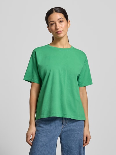 Frauenmodel trägt Loose Fit T-Shirt aus reiner Baumwolle Modell 'VALLEY' von American Vintage in Grün, lässiger Schnitt, Ganzkörperansicht von vorne.