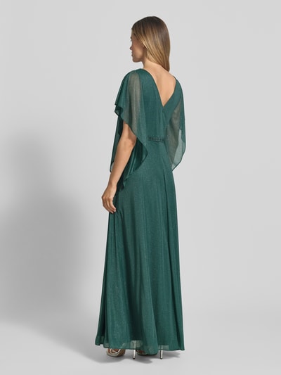 Frauenmodel trägt Maxikleid in Glitzer-Optik mit V-Ausschnitt von Vera Mont, taillierte Passform, Falten, Volantärmel, Ziersteinbesatz, Rückenlänge bei Größe 38: 133 cm, Brustweite: 42 cm, Ärmellänge: 24 cm, Ganzkörperansicht Rückansicht.
