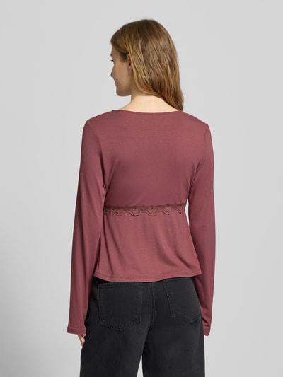 Vrouwenmodel draagt Slim Fit Langarmshirt uit viscosemix model 'SINI' van Only, rood, kantdetail, labelstiksel, rugaanzicht.