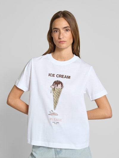 Frauenmodel trägt T-Shirt mit Motiv-Print Modell 'CAMINO' von Samsøe Samsøe aus weißer Baumwolle, Regular Fit, Rundhalsausschnitt, Ganzkörperansicht von vorne.