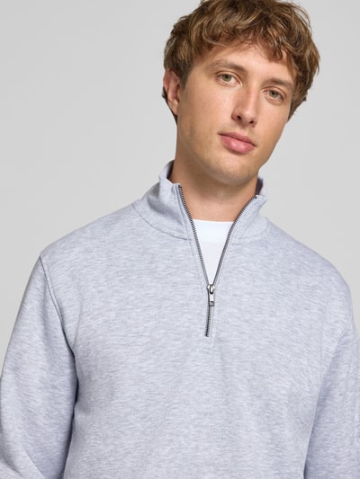 Männermodel trägt Regular Fit Sweatshirt mit Baumwoll-Anteil Modell 'Bradley' von JACK & JONES, hellgrau, meliert, Nahaufnahme Oberkörper. Material-Mix, Troyer-Kragen.