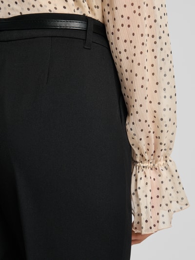 Frauenmodel trägt Barrel Fit Stoffhose mit Gürtel Modell 'ELMA' von Vero Moda in Schwarz, unifarben mit Bundfalten und seitlichen Taschen, Nahaufnahme Rückansicht.