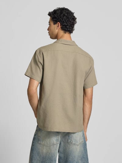 Męski model nosi Regular Fit Freizeithemd mit Strukturmuster Modell 'Global' od Jack & Jones z bawełny, krój regular fit, kołnierz z połami, z krótkim rękawem i listwą guzikową, fakturowany wzór, beżowy kolor, długość tyłu w rozmiarze M 71 cm, szerokość ramion w rozmiarze M 51 cm, długość rękawa w rozmiarze M 25 cm, widok całej sylwetki z tyłu.