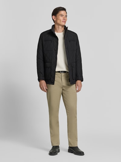 Männermodel trägt Regular Fit Jacke in Stepp-Optik von bugatti, schwarz, Stehkragen, Knopfleiste, Ganzkörperansicht von vorne.