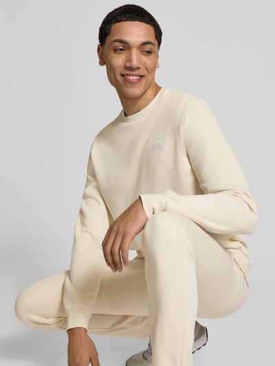Männermodel trägt Regular Fit Sweatshirt mit Logo-Stitching von PUMA PERFORMANCE in Beige, Baumwoll-Mix, Nahaufnahme Oberkörper.