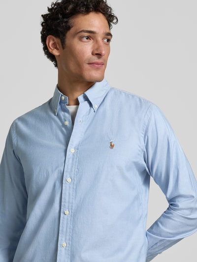 Männermodel trägt Regular Fit Freizeithemd aus Baumwoll-Mix von Polo Ralph Lauren in Hellblau, mit Knopfleiste, Nahaufnahme Oberkörper.