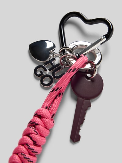 Produktfoto, Schlüsselanhänger mit Wickeloptik Kurdel Modell 'NEEKO_CHARM' von HUGO, pink mit schwarzen Details, Logo-Applikation, metallische Akzente.