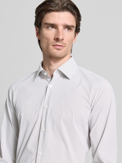 Männermodel trägt Regular Fit Businesshemd mit Kentkragen Modell 'JOE' von BOSS mit feiner Webstruktur, Allover-Streifenmuster, Nahaufnahme Oberkörper.