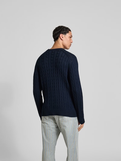 Männermodel trägt Slim Fit Pullover in Strick-Optik von Filippa K in Dunkelblau, reine Baumwolle, elastische Abschlüsse, Ganzkörperansicht Rückansicht.