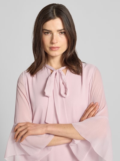 Frauenmodel trägt Knielanges Kleid mit Schleifen-Detail Modell 'Denia' von JOOP! in zartem Rosa, Lagenlook, Nahaufnahme Oberkörper.