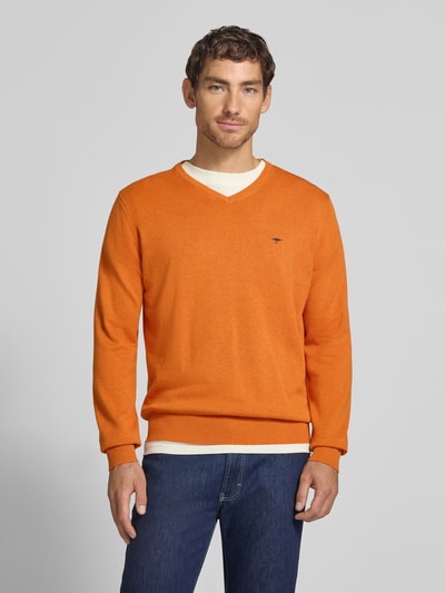 Männermodel trägt Strickpullover mit Label-Strickerei von Fynch-Hatton in Orange, reine Baumwolle, gerader Schnitt, Ganzkörperansicht von vorne.