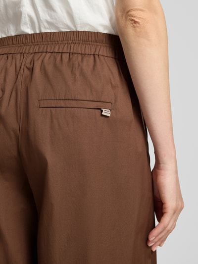 Frauenmodel trägt braune Culotte mit Gesäßtaschen Modell 'CAROLINE' von MAC aus Baumwoll-Mix mit Stretch-Anteil, Detailaufnahme Rückansicht.