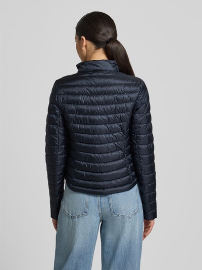 Frauenmodel trägt Steppjacke mit Stehkragen von Gil Bret, Körpernahe Passform, Zweiwege-Reißverschluss, Reißverschlusstaschen, Rückenlänge 56 cm, Schulterbreite 39 cm, Brustweite 47 cm, Ärmellänge 66 cm, dunkelblau, glatte Struktur, Ganzkörperansicht Rückansicht.