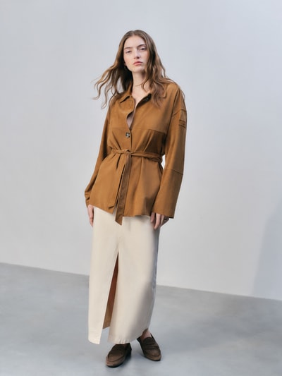 Frauenmodel trägt Jacke in Suede-Optik Modell 'Machuca' von Peuterey mit Tailliert Passform, Umlegekragen, Abnehmbare Taillenband, Knopfleiste, Rückenlänge 72 cm, Schulterbreite 42 cm, Brustweite 54 cm, Ärmellänge 53 cm, Ganzkörperansicht von vorne.