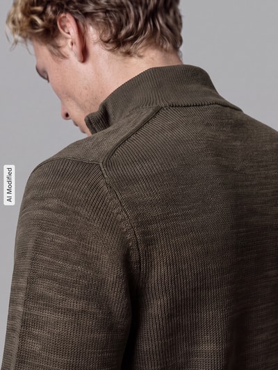 Männermodel trägt Regular Fit Troyer aus reiner Baumwolle Modell 'DANE' von Selected in Olivgrün, grob gestrickte Textur, Nahaufnahme Rückenansicht, KI-modifiziertes Bild.