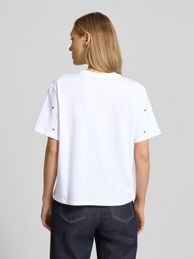 Frauenmodel trägt Boxy Fit T-Shirt aus reiner Baumwolle von Tom Tailor Denim, unifarben mit Allover-Herz-Stickerei, Ganzkörperansicht Rückansicht.
