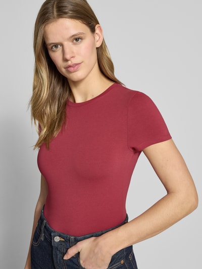 Frauenmodel trägt Slim Fit T-Shirt mit Rundhalsausschnitt von Review, bordeauxrot, elastischer Baumwoll-Mix, Nahaufnahme Oberkörper.